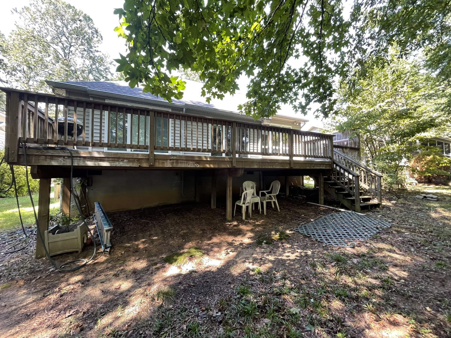 The backyard of a house with a large deck and stairs.