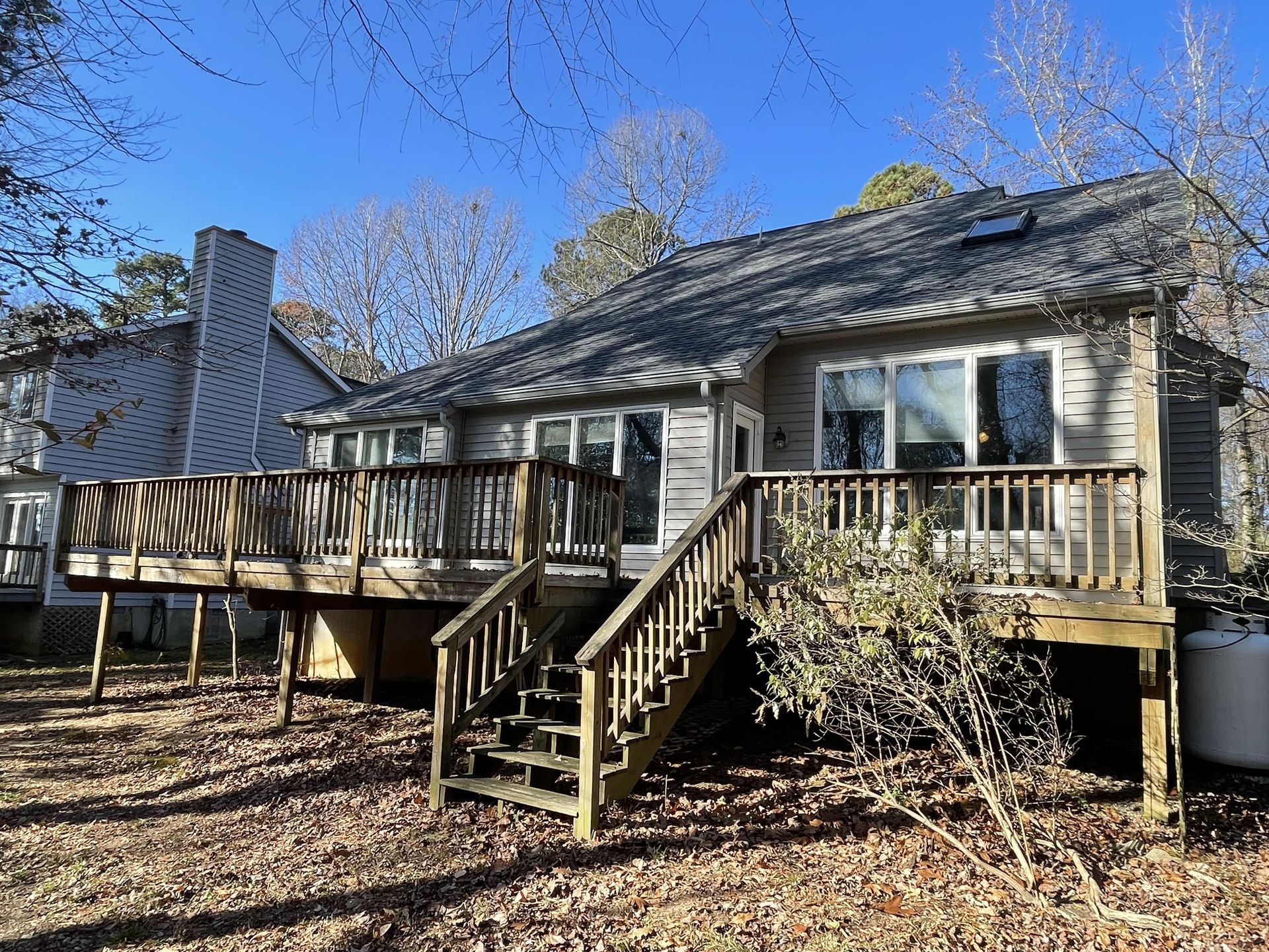 The back of a house with a large deck and stairs.