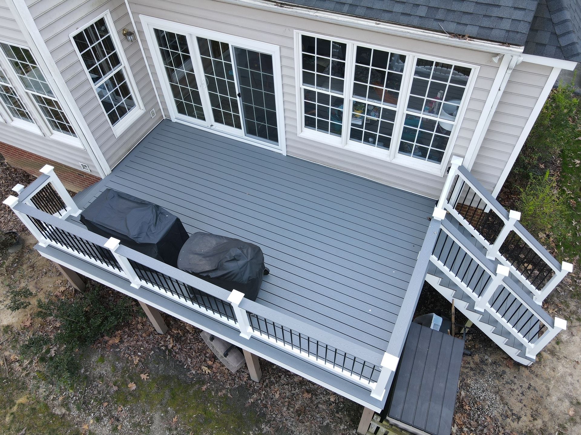 An aerial view of a house with a large deck and stairs.