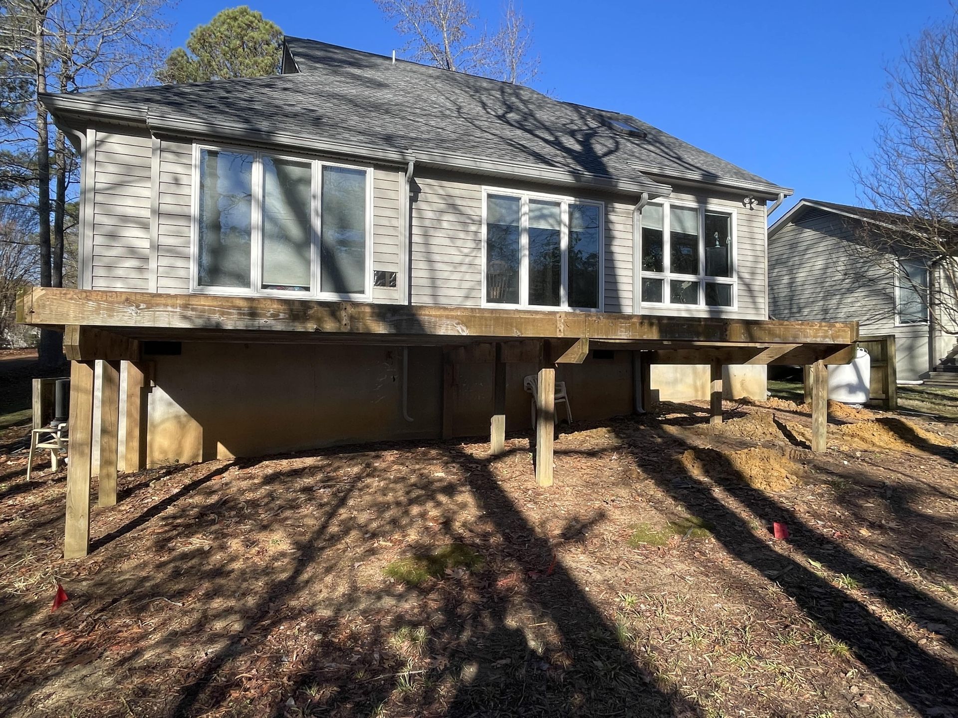 The back of a house with a deck and a lot of windows.