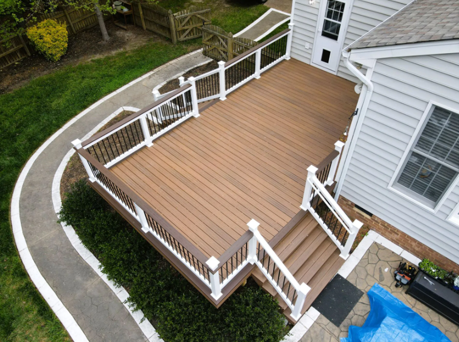 Deck with wooden railing and pool, built by a deck-building company for outdoor relaxation.
