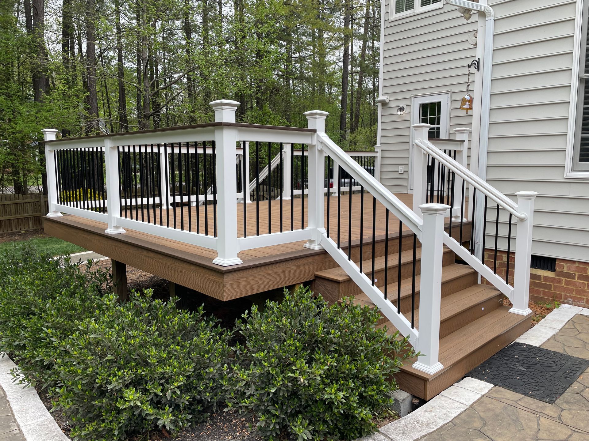 A deck with stairs leading up to it and a white railing.
