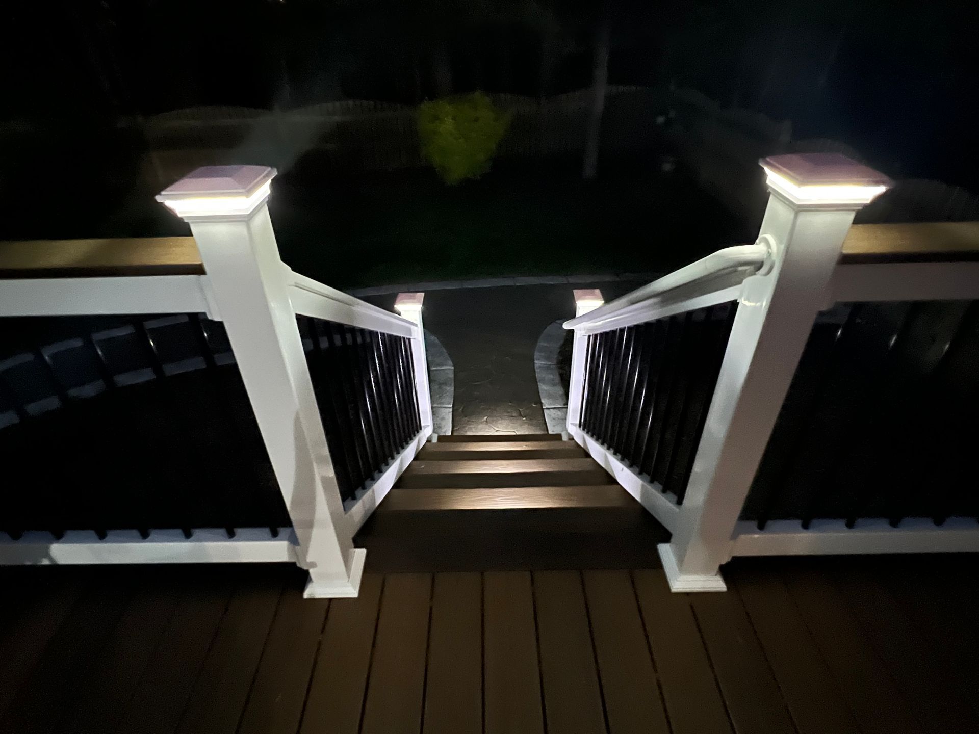 A deck with stairs that are lit up at night