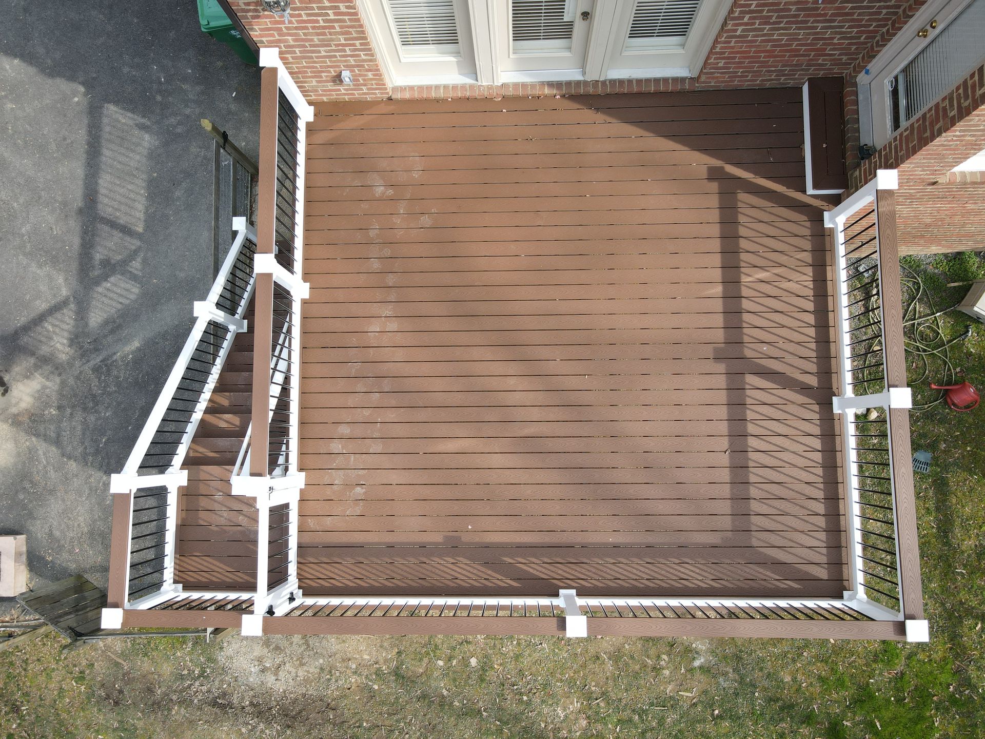 An aerial view of a deck in front of a brick house