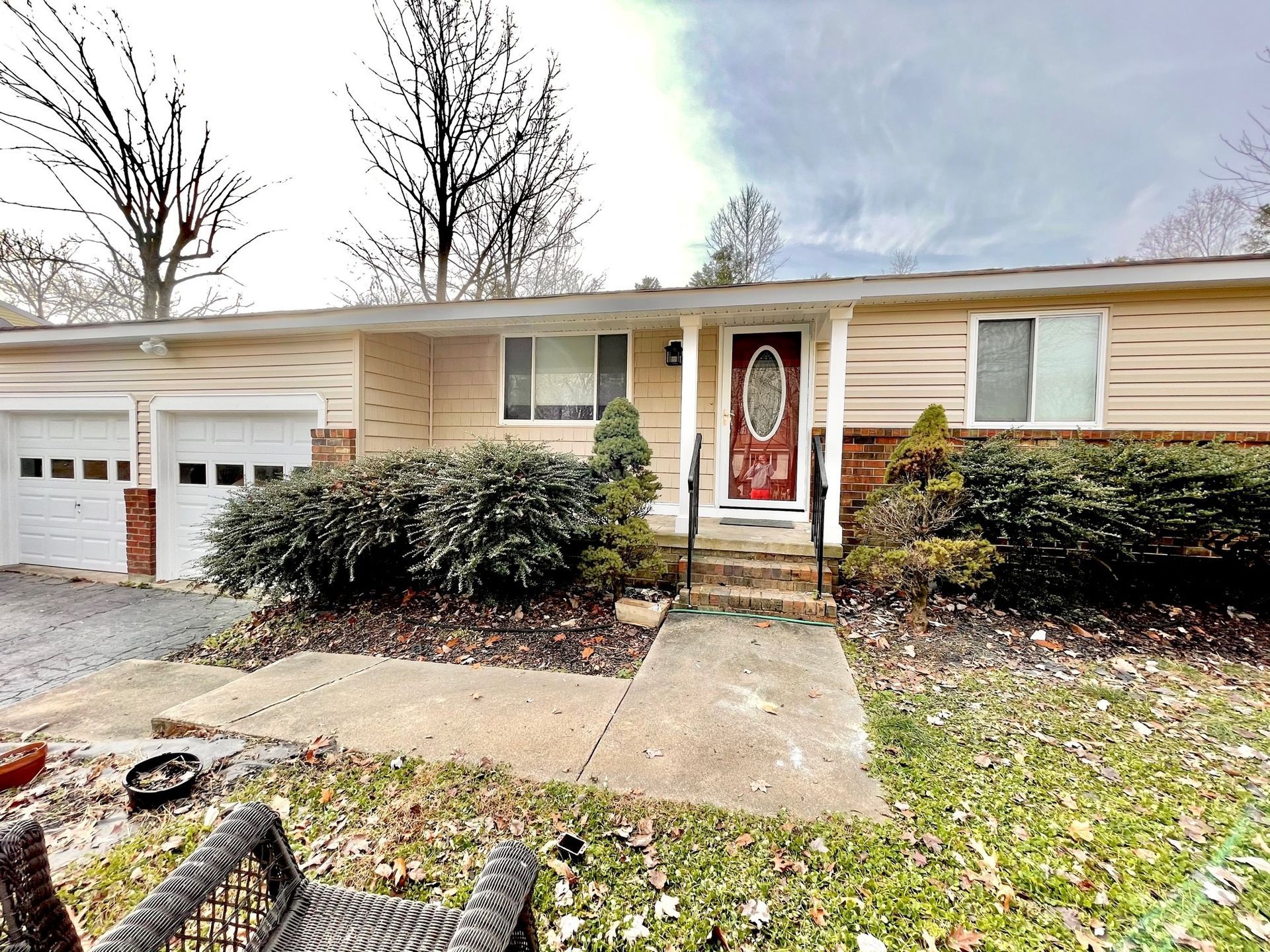 The front of a house with a red door and two garages.