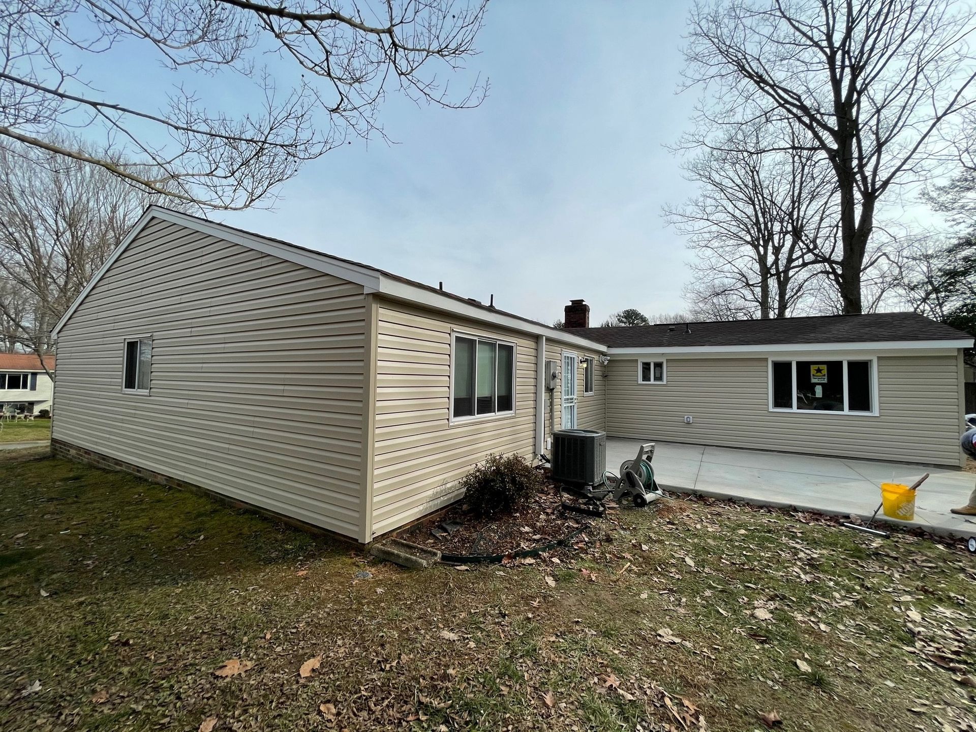 The back of a house with a lot of windows and siding.