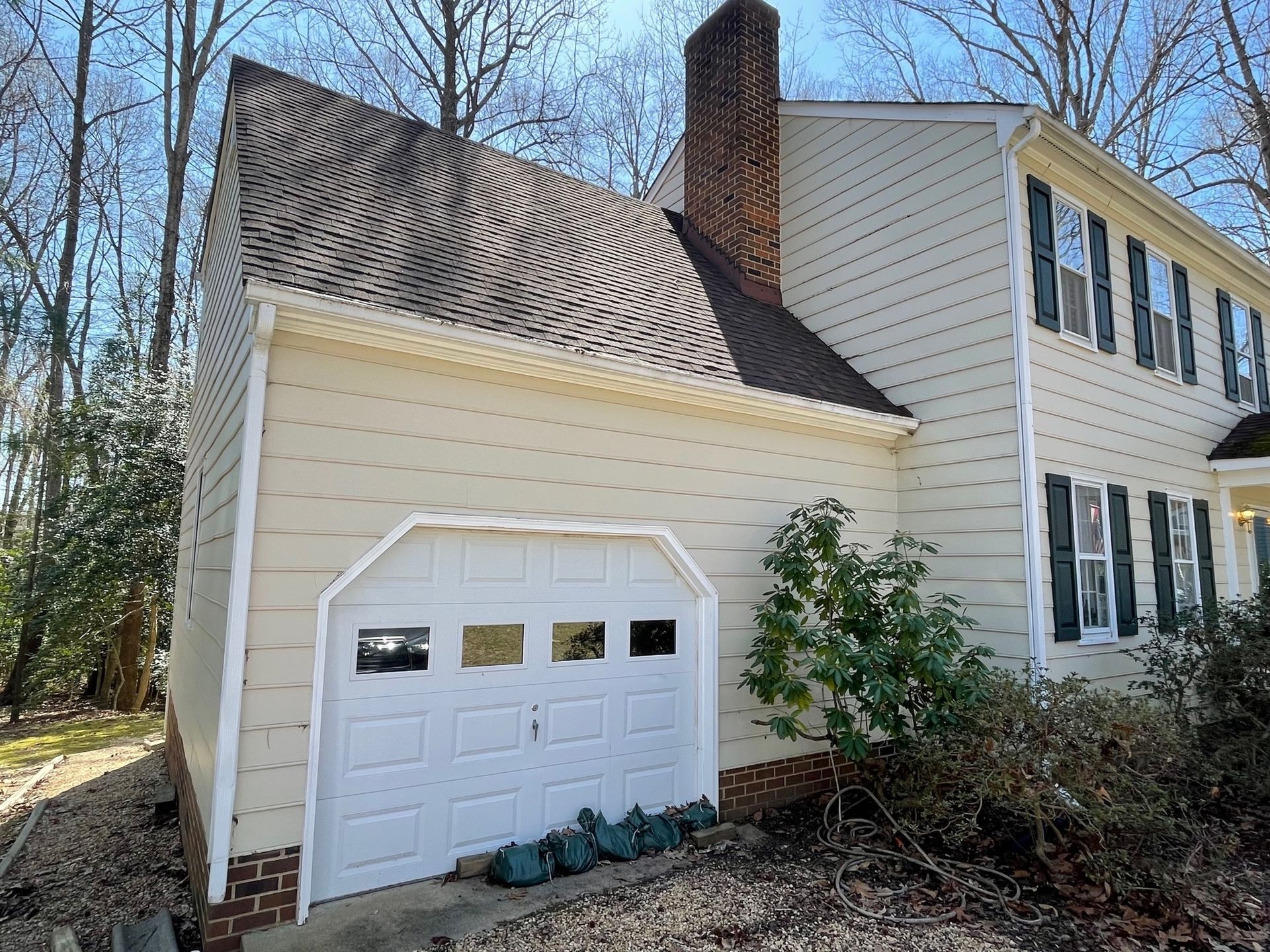 A large white house with a garage and a chimney.