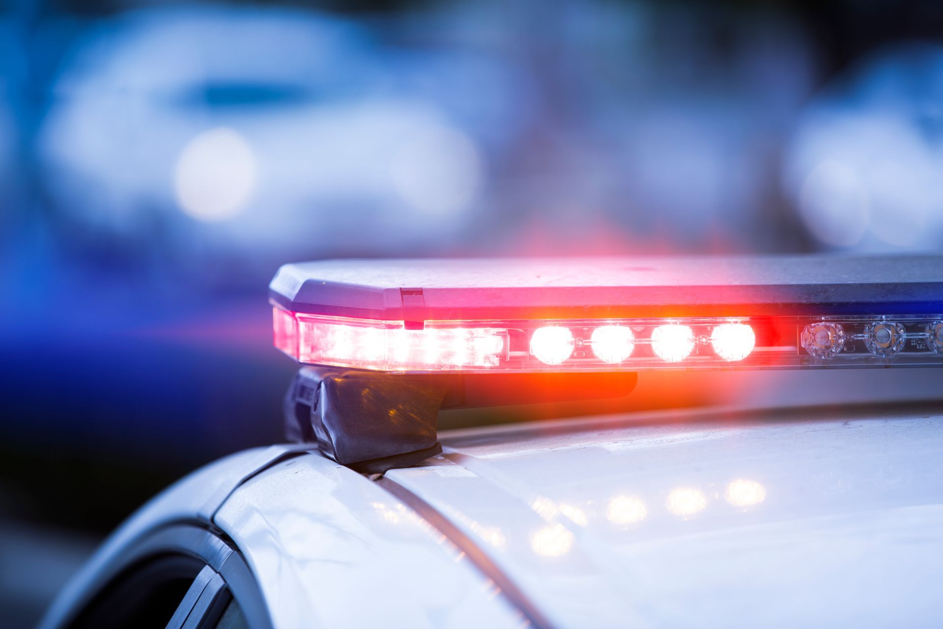 A close up of a police car with its lights on.