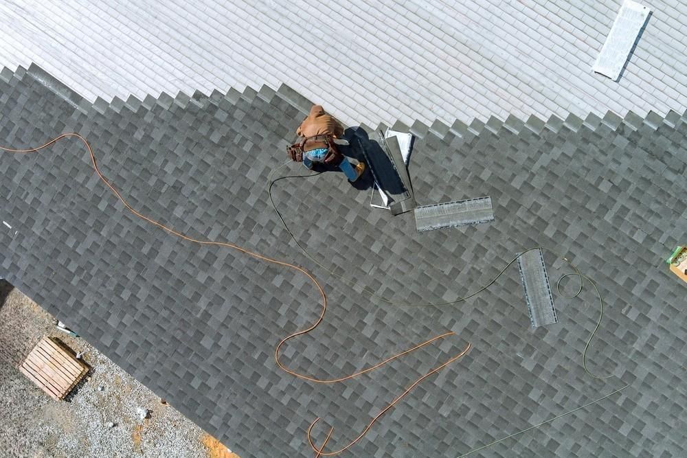 Roof shingle repair in progress, showcasing precision work with a nail gun and hammer, emphasizing skilled craftsmanship and attention to detail.