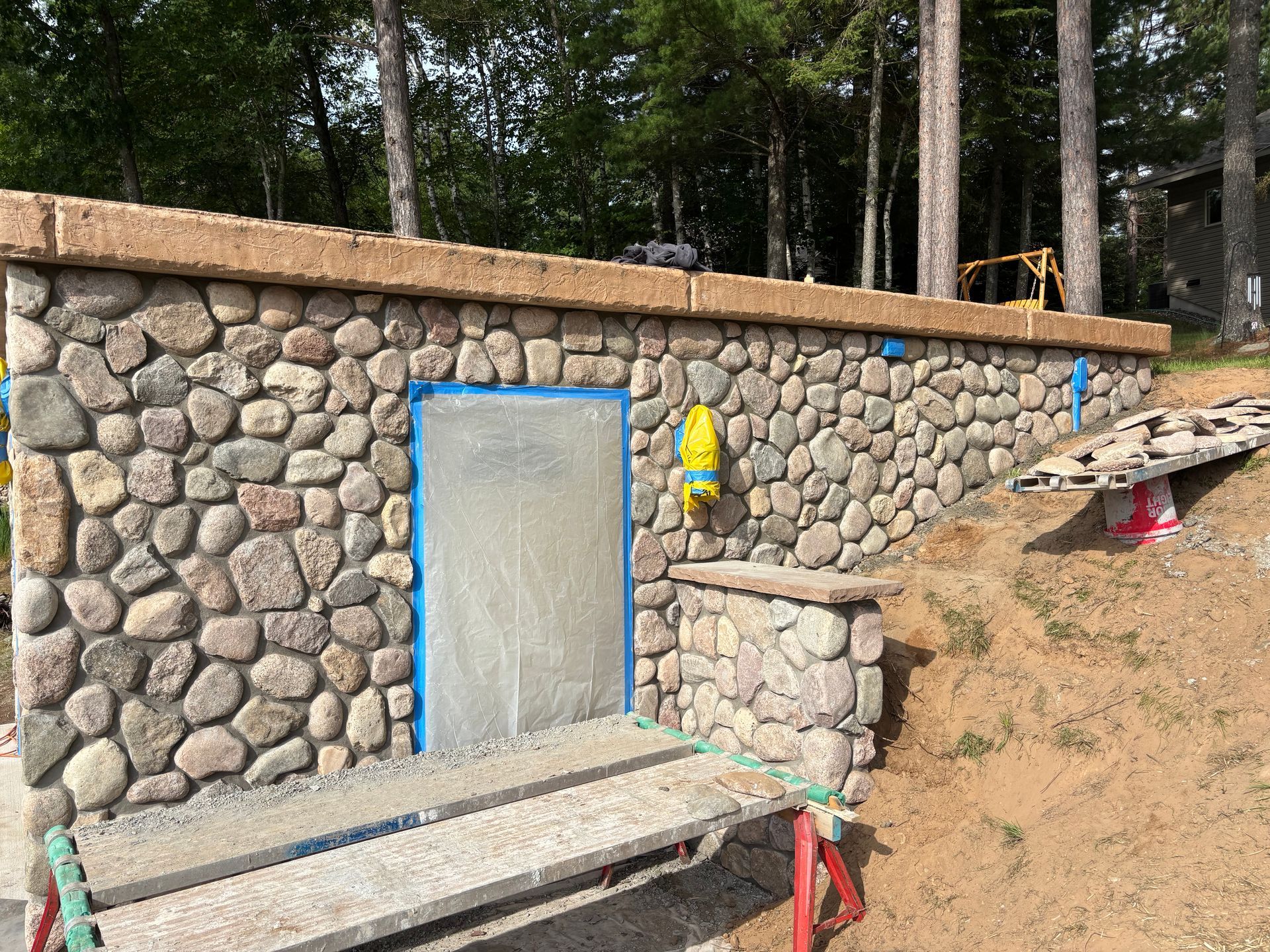 Stone building with a door, wooden trim, and small platform.