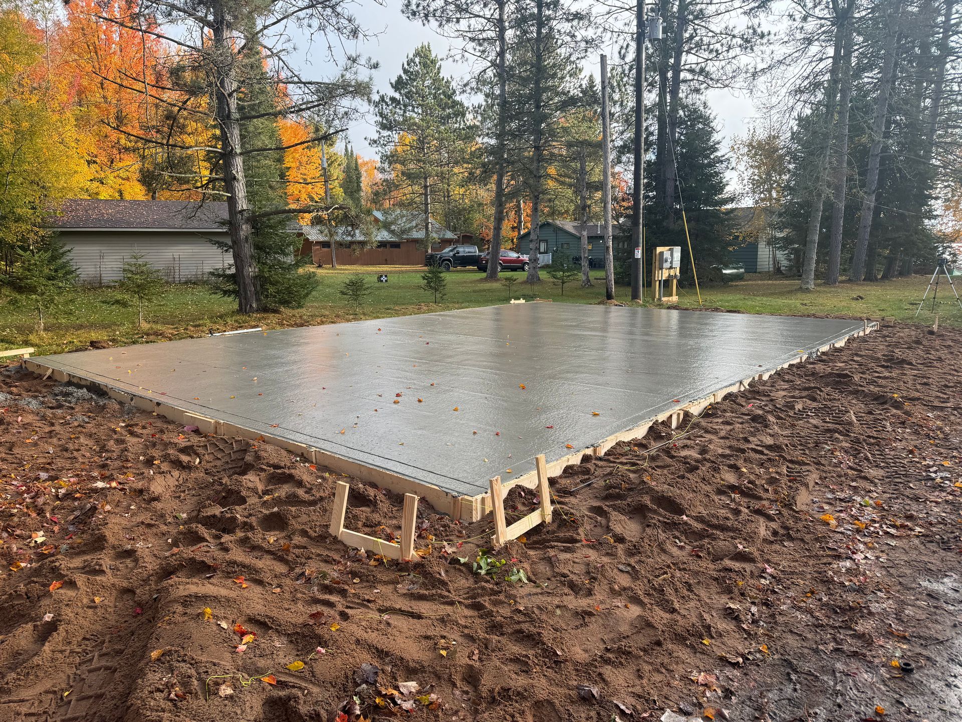 Freshly poured concrete foundation bordered by wood frame, outdoors.