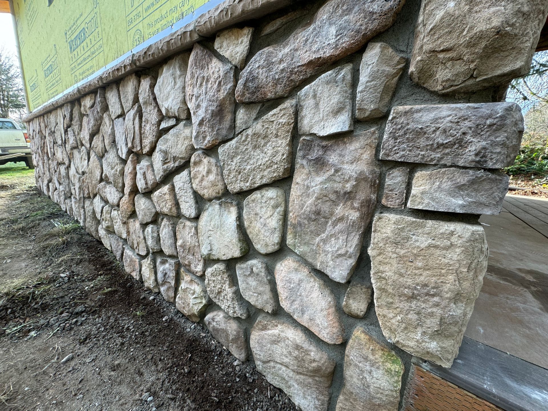Stone veneer on the exterior of a building, featuring various sized natural rocks set in mortar.