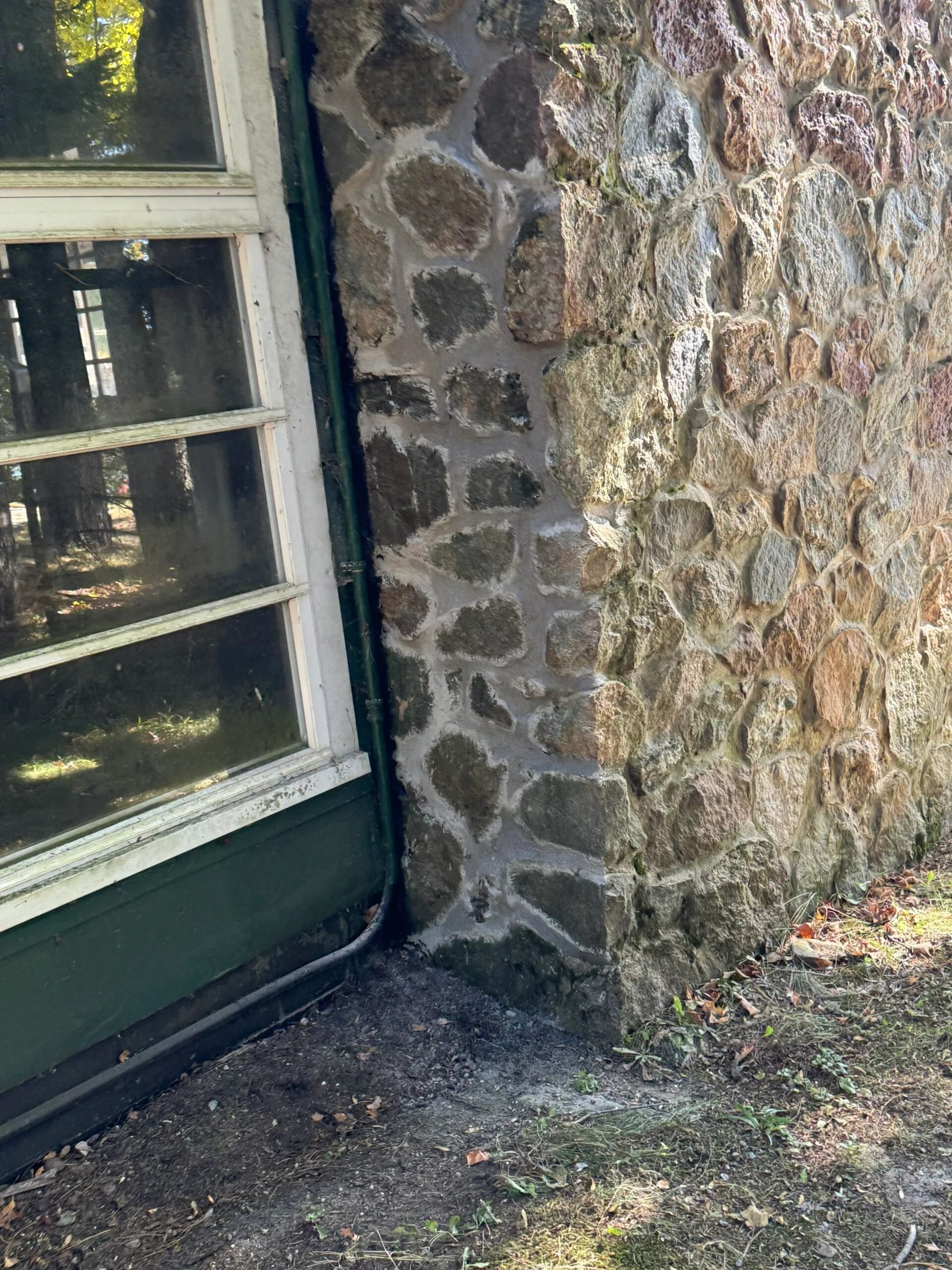A stone wall with a window next to it.