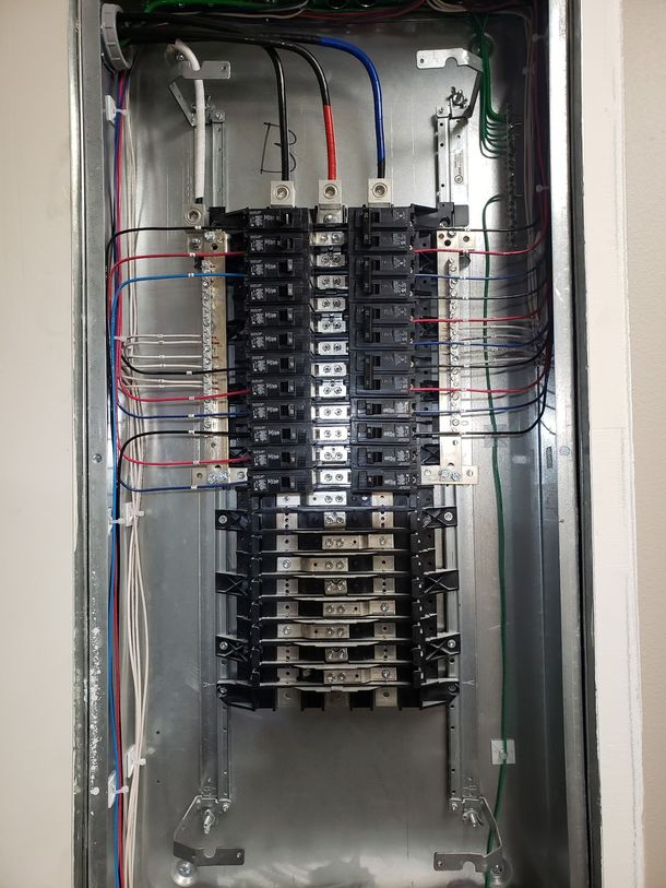A close up of a electrical box with a lot of wires coming out of it.