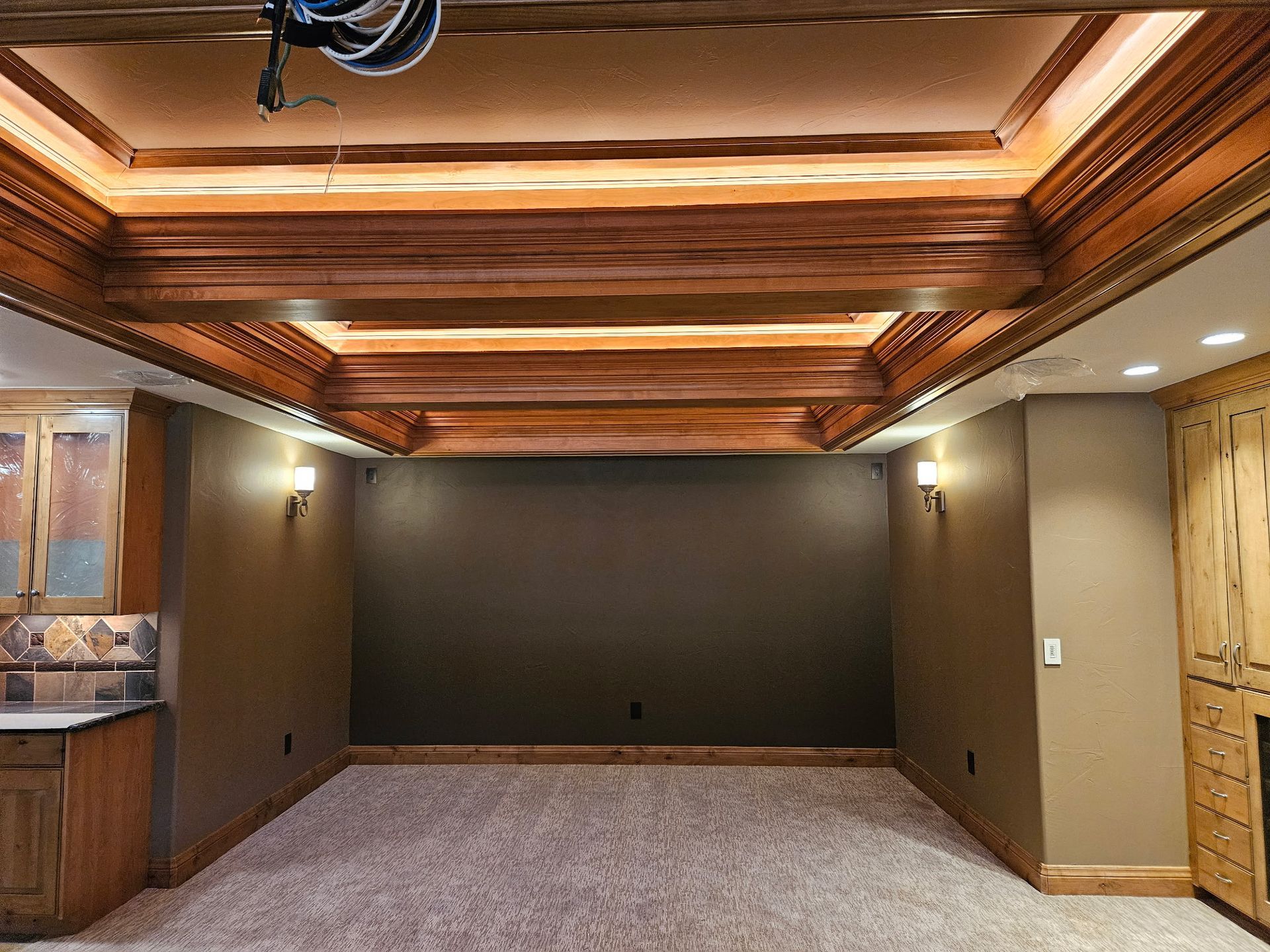 An empty basement with a wooden ceiling and a carpeted floor.