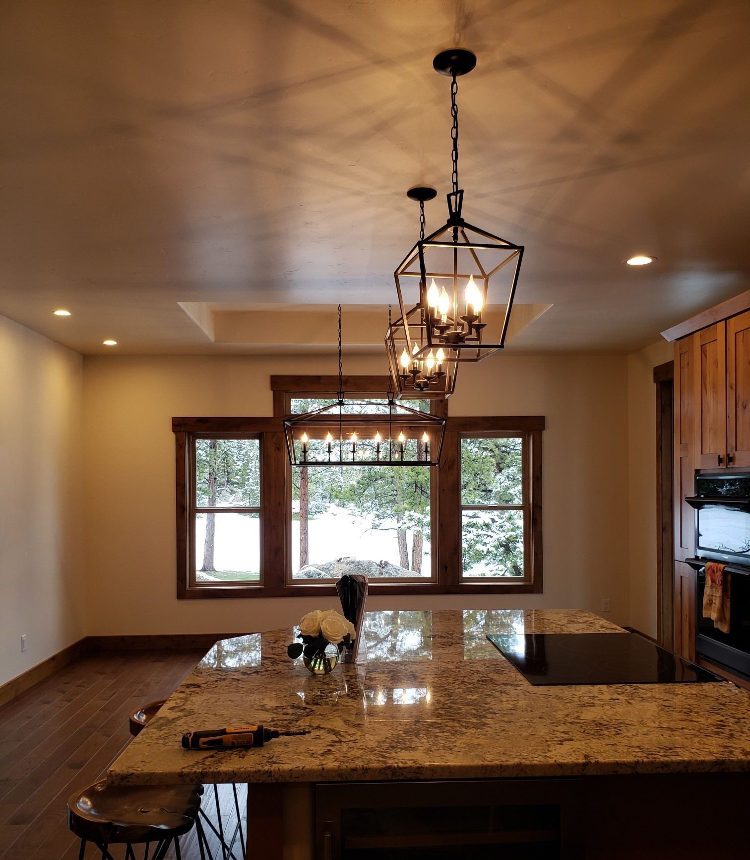 A kitchen with a large island and a chandelier hanging from the ceiling