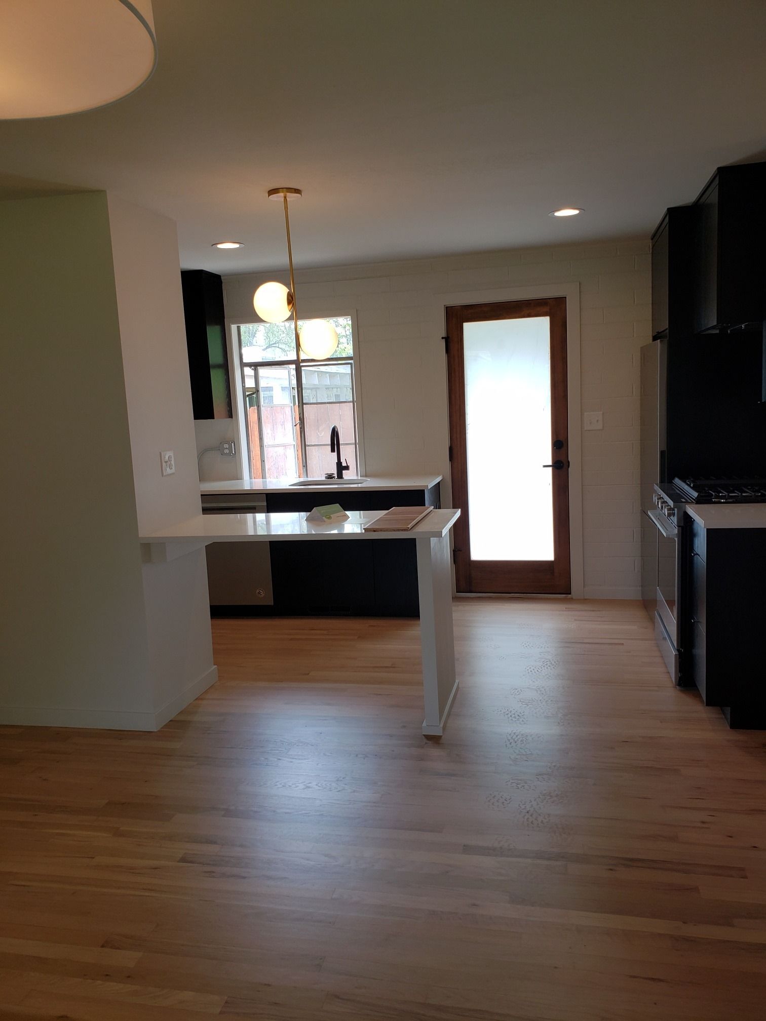 A kitchen with a wooden floor and a glass door