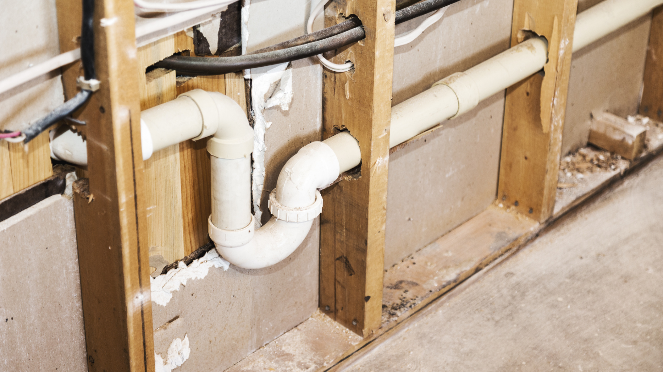 A plumbing pipe is being installed in a wooden frame.