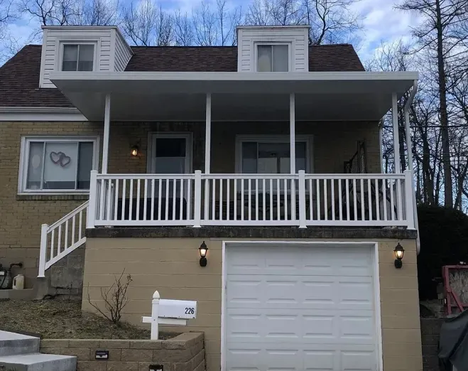 Front of a house with a white porch and garage.