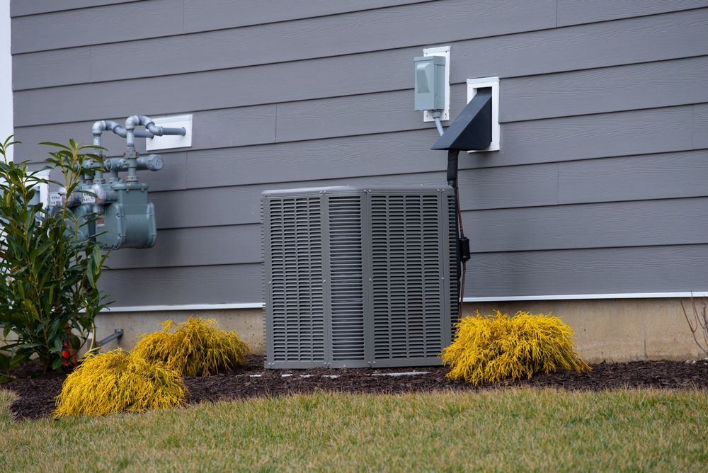 An air conditioner is sitting on the side of a house.