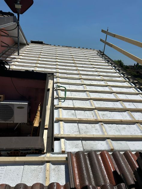 Persona che posa piastrelle decorate su una parete utilizzando la malta.