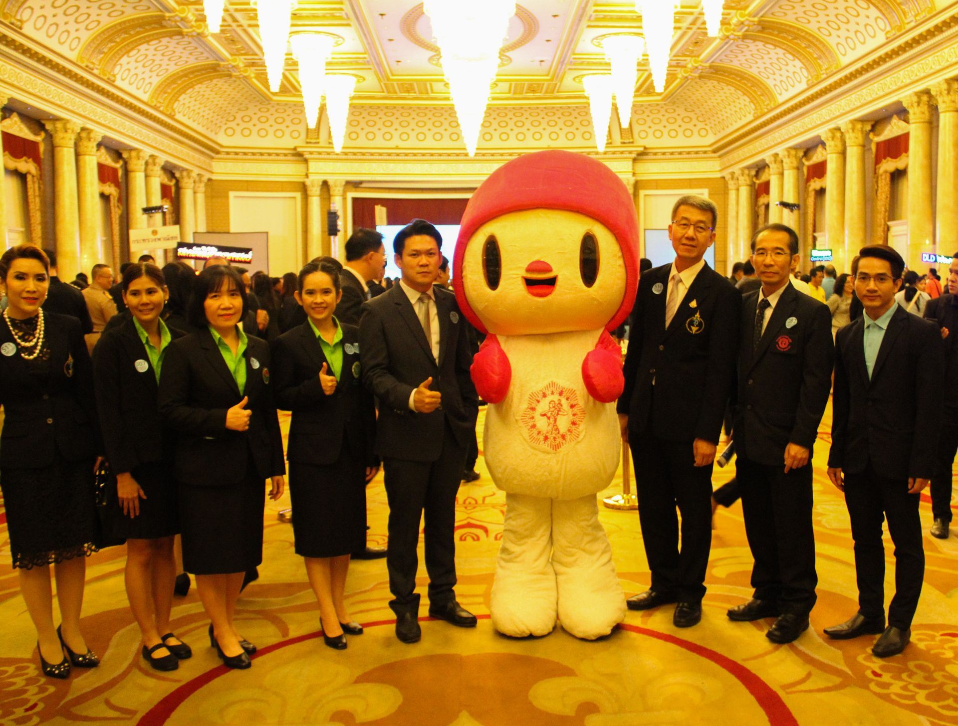 A group of people are posing for a picture with a mascot