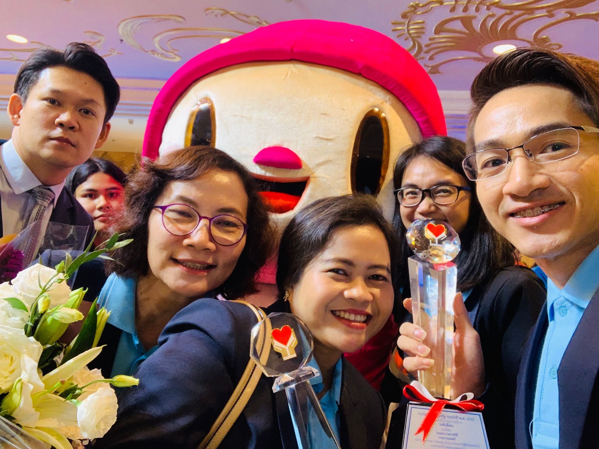 A group of people are posing for a picture with a mascot.