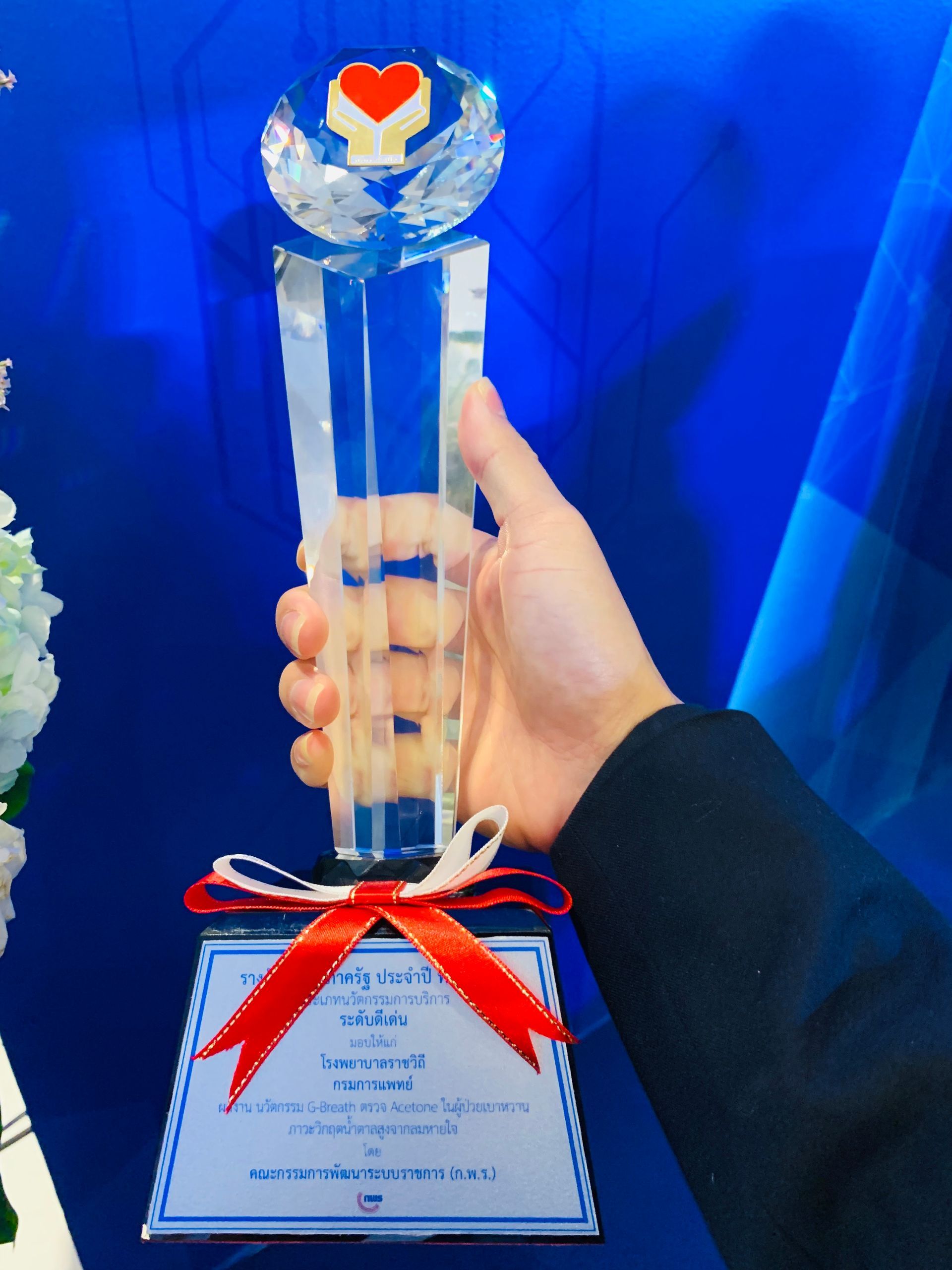 A person is holding a trophy with a heart on it