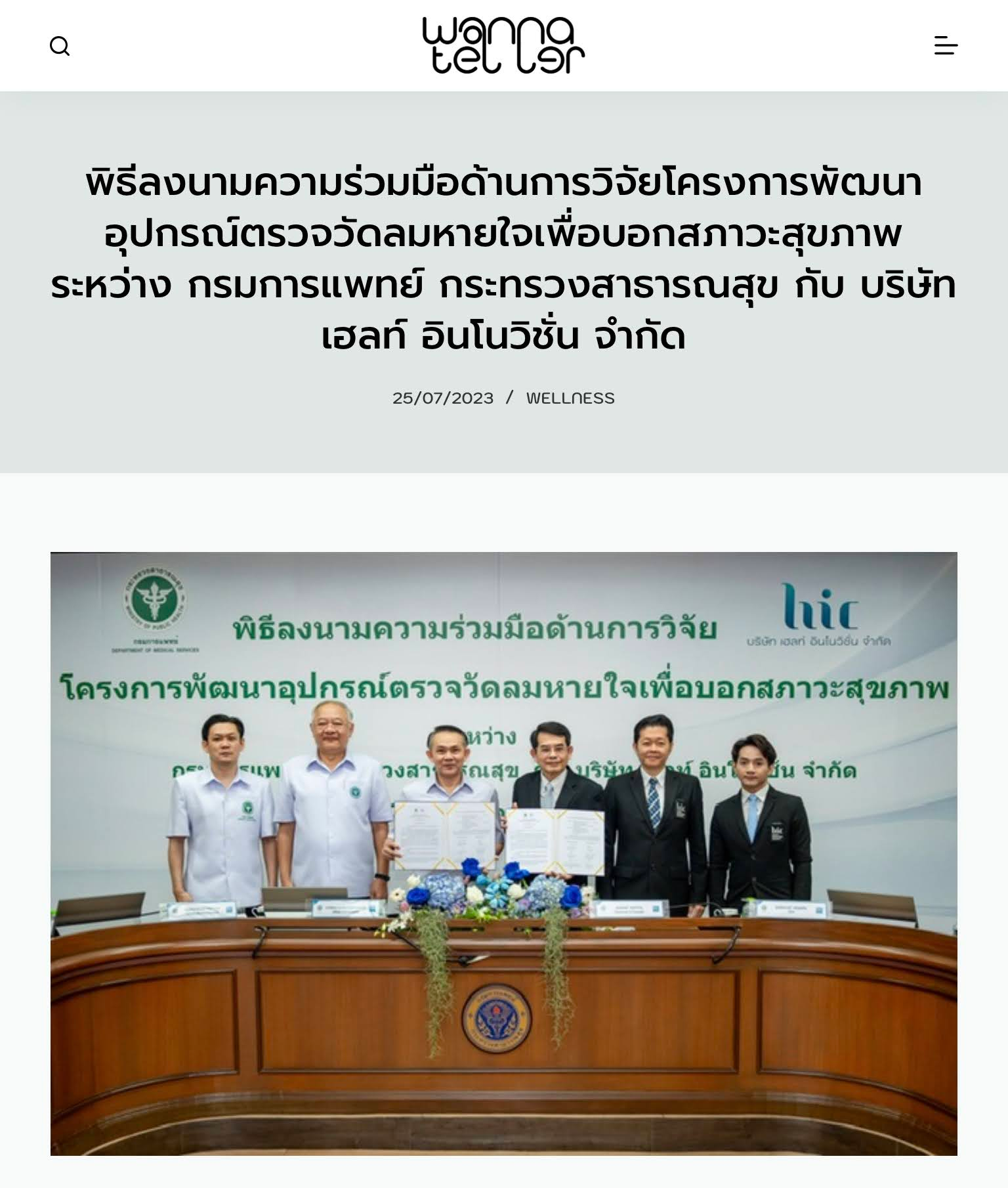 A group of men are standing in front of a large wooden table.