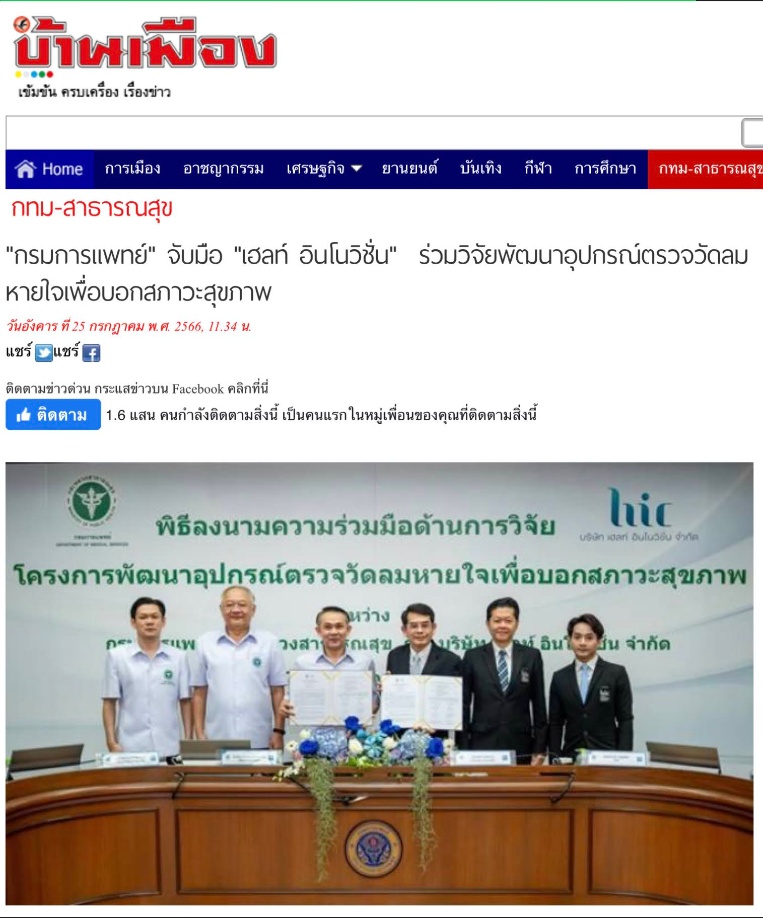 A group of men are standing in front of a table holding papers.