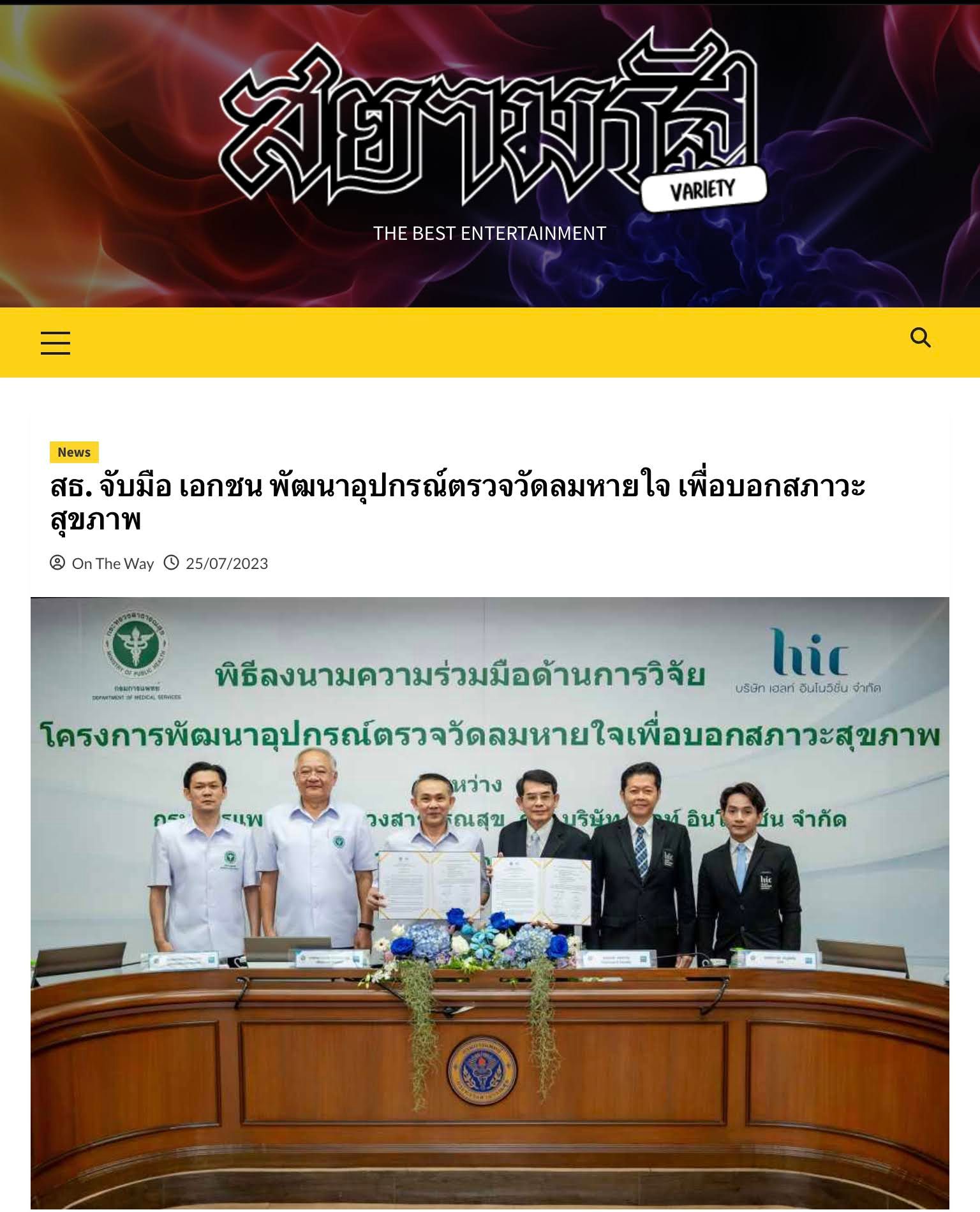 A group of men are standing around a table in front of a magazine.