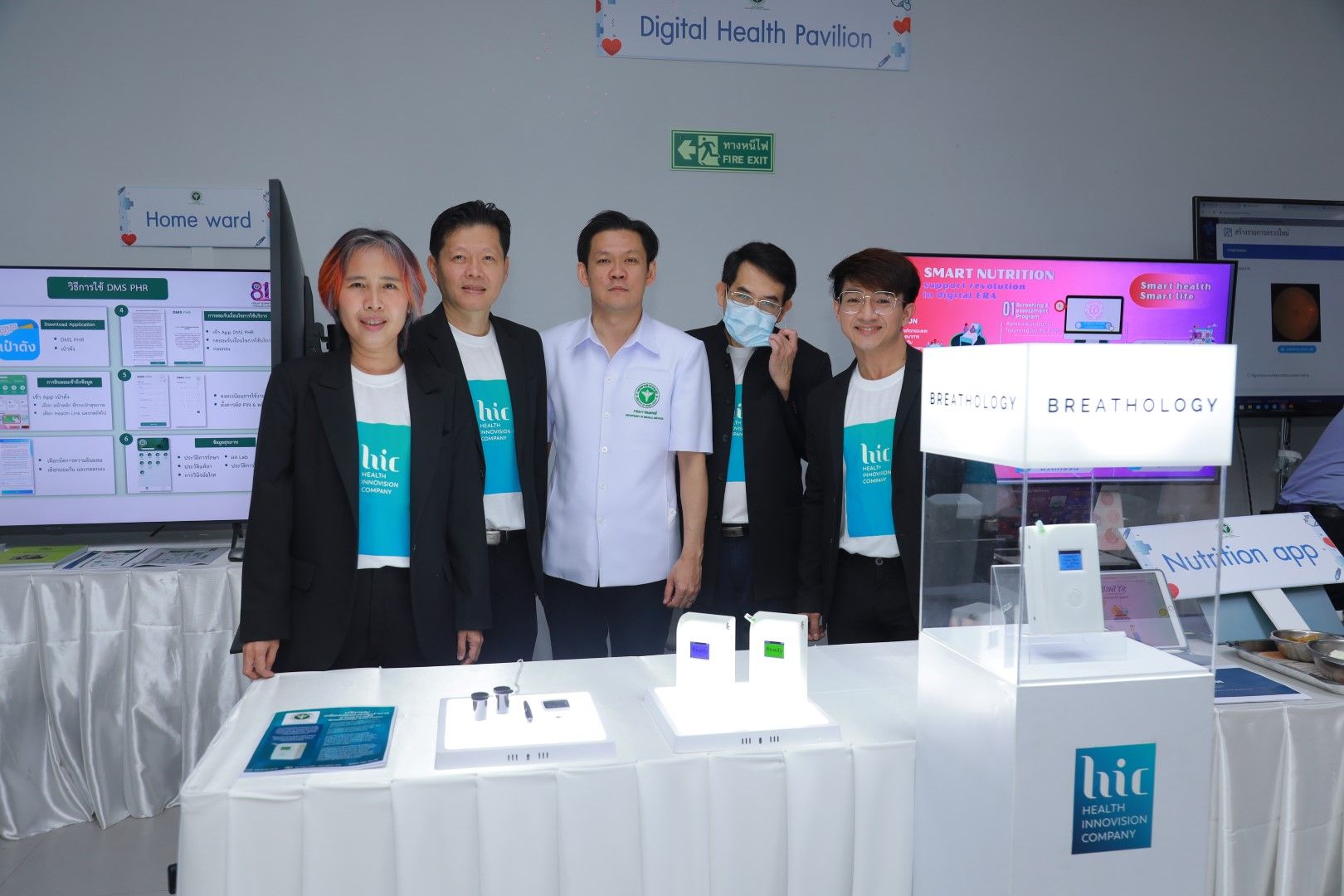A group of people are posing for a picture in front of a table.