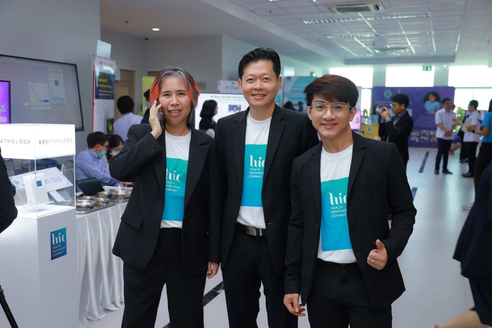 Three men in suits are standing next to each other in a room.