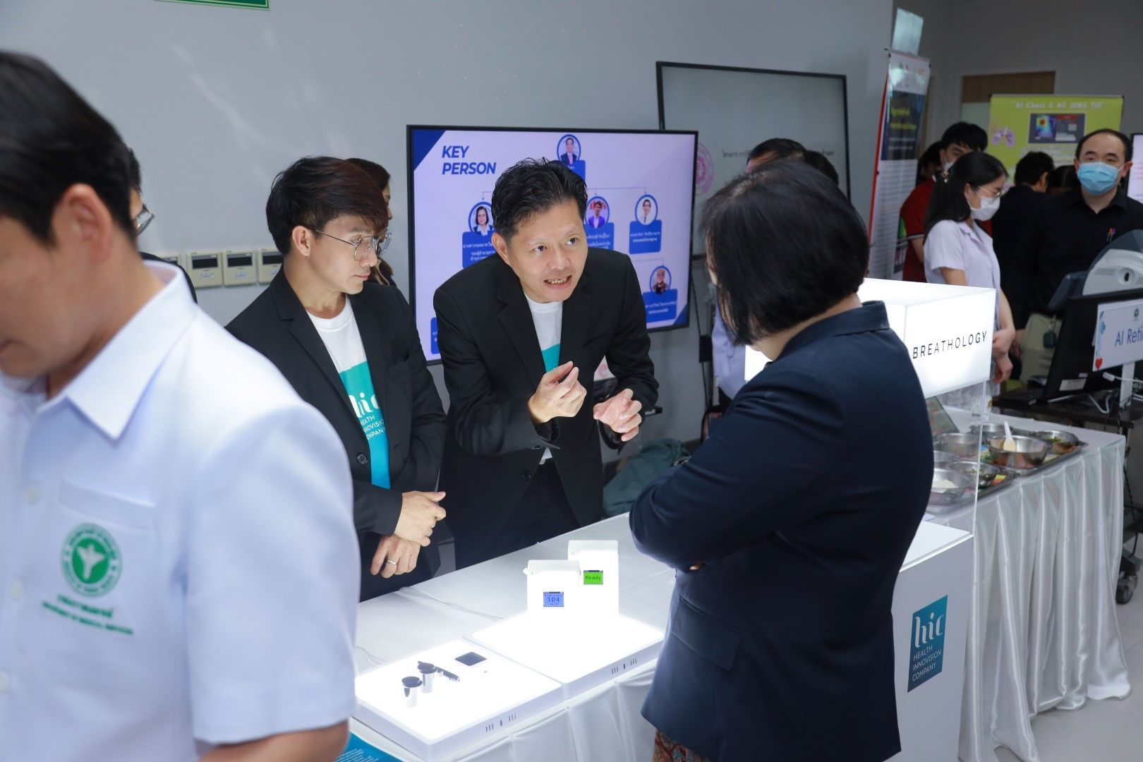 A group of people are standing around a table in a room.