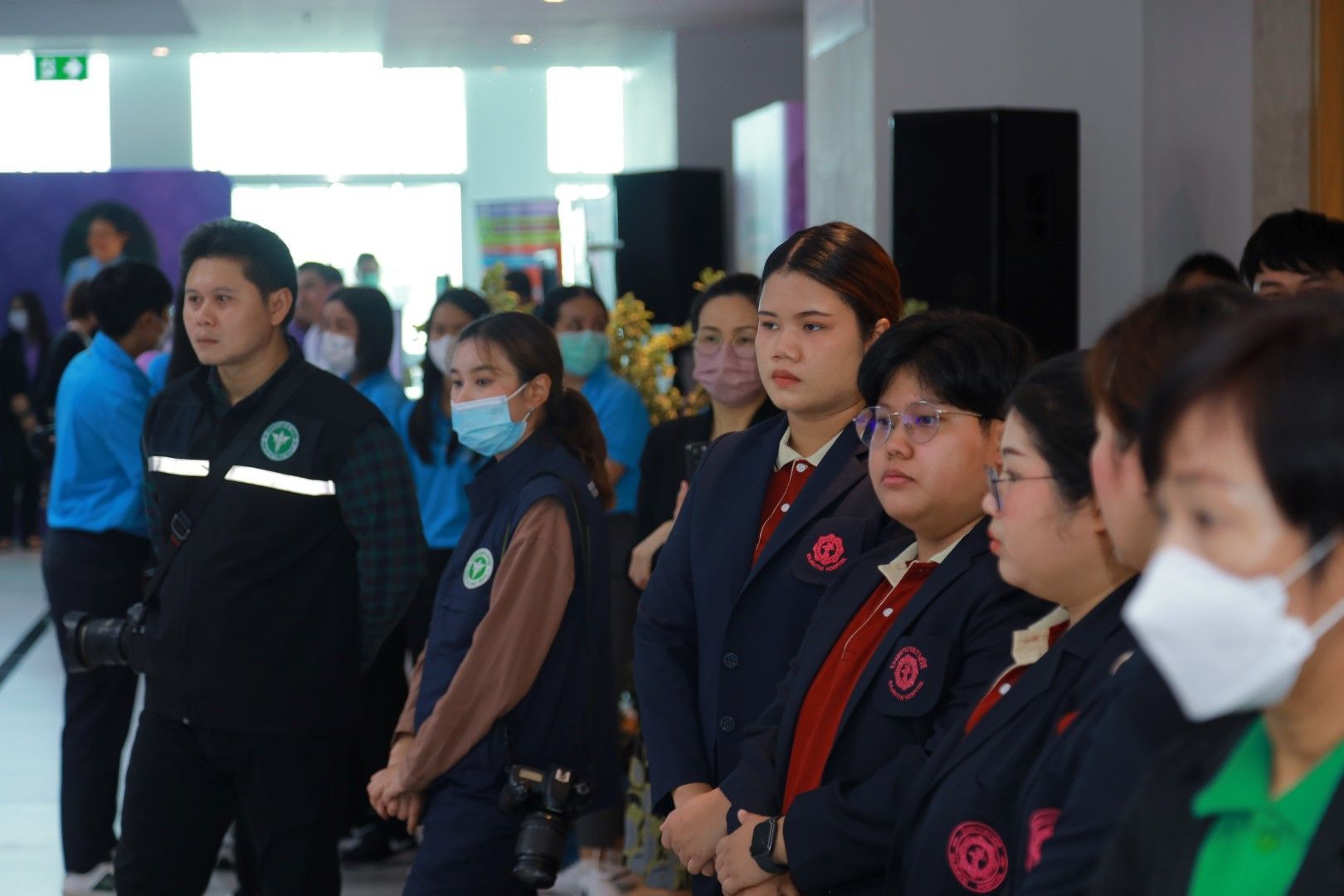 A group of people wearing masks are standing in a line.
