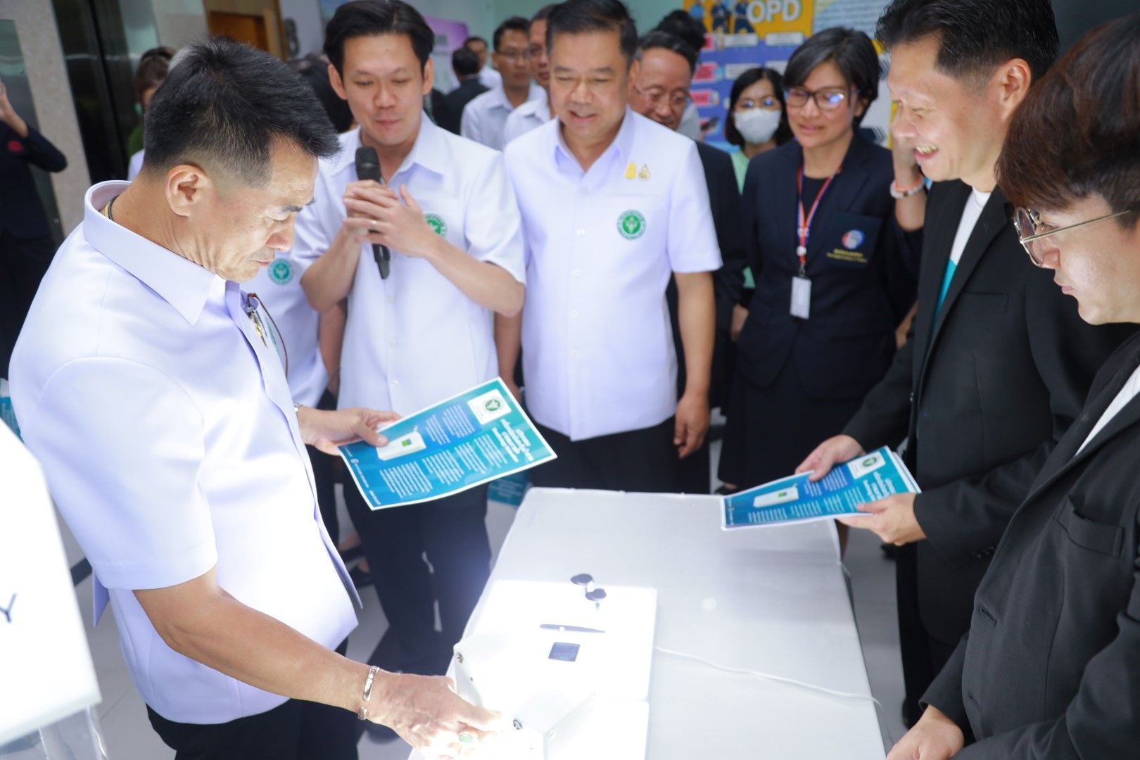A group of people are standing around a table.
