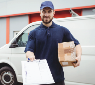 Delivery person holding a package and clipboard in front of a white van.