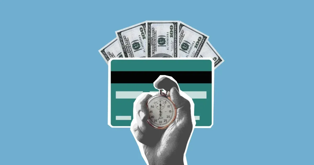 Hand holding pocket watch in front of credit card and cash against a light blue background.