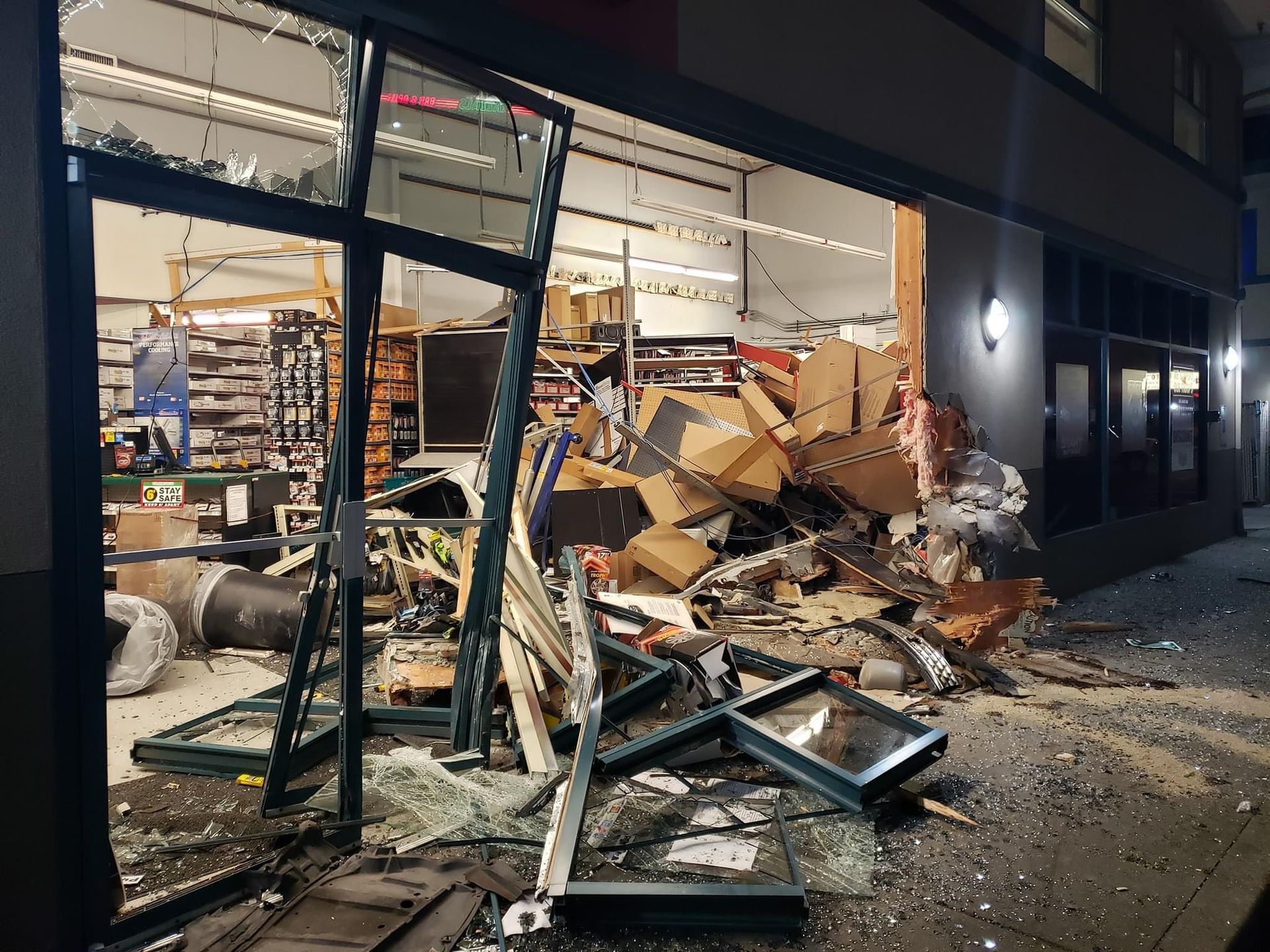 A store front with a lot of broken glass and boxes.