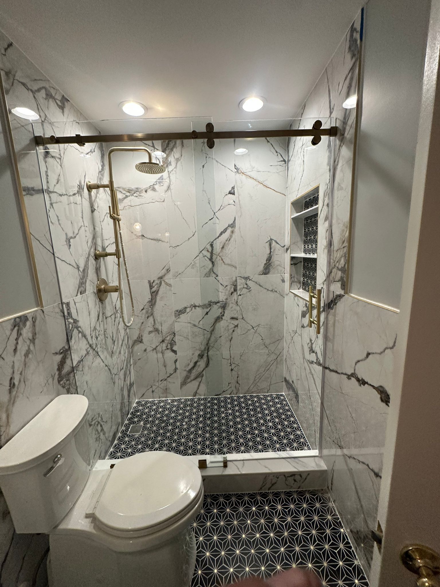 A bathroom with a toilet , shower , and mirror.