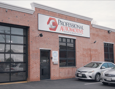 A red brick automotive repair shop with a sign reading 