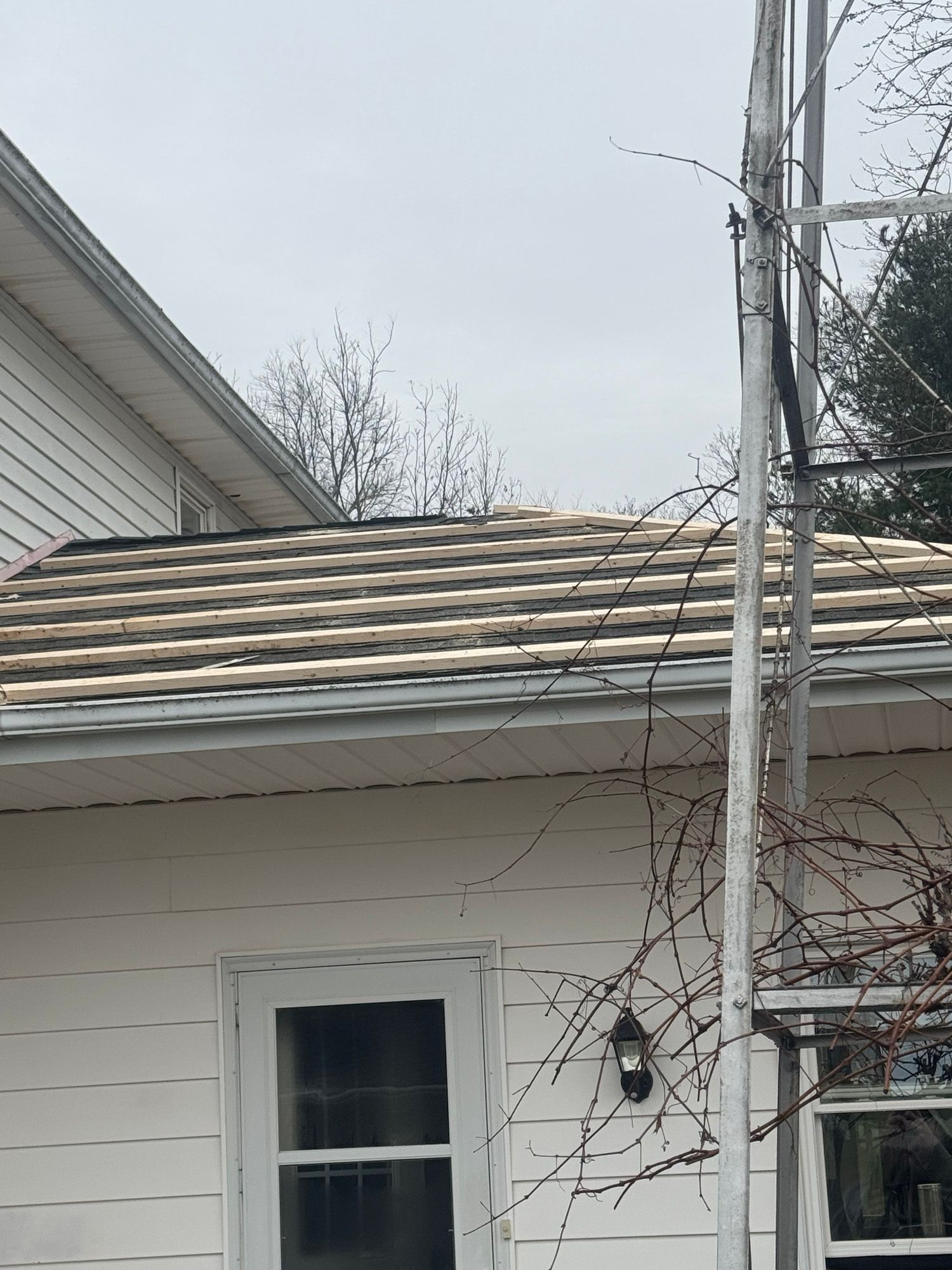 A white house with a roof that is being repaired.