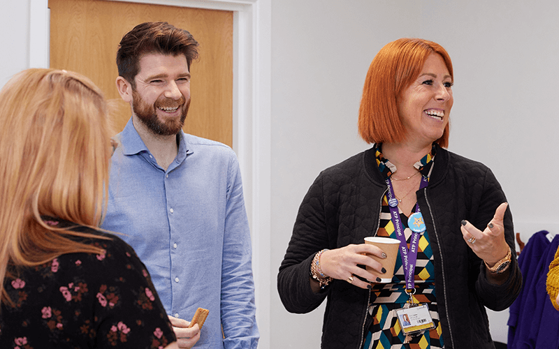 Two women are talking to each other through a glass door.