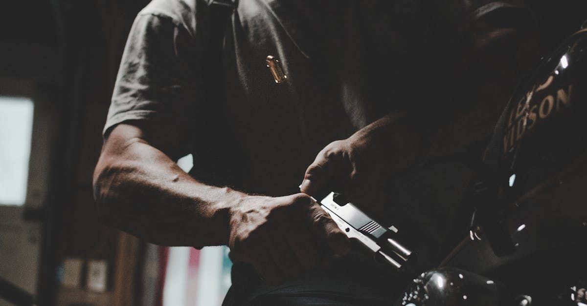 A man is working on a motorcycle in a dark room.