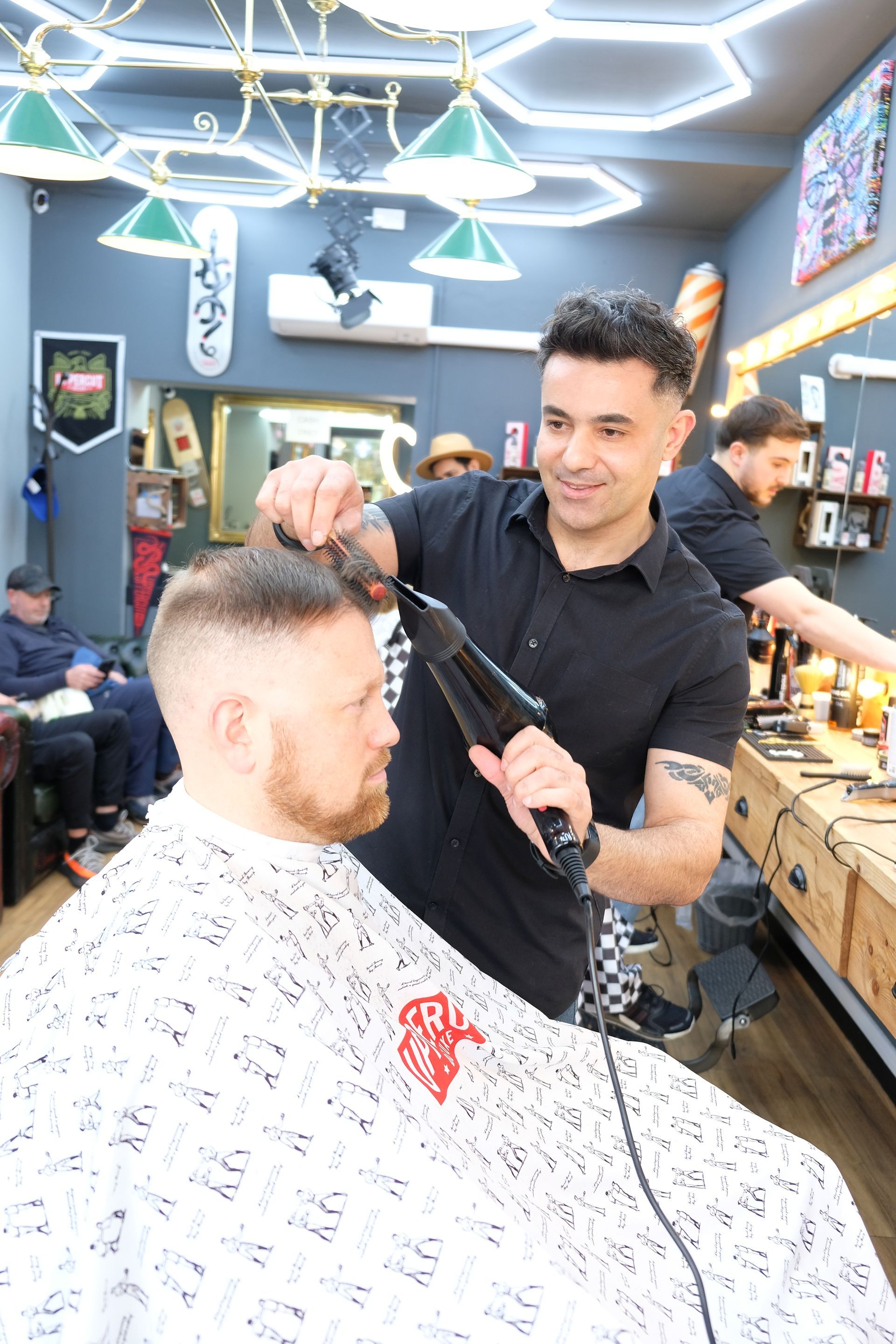 A man is getting his hair cut by a barber in a barber shop.