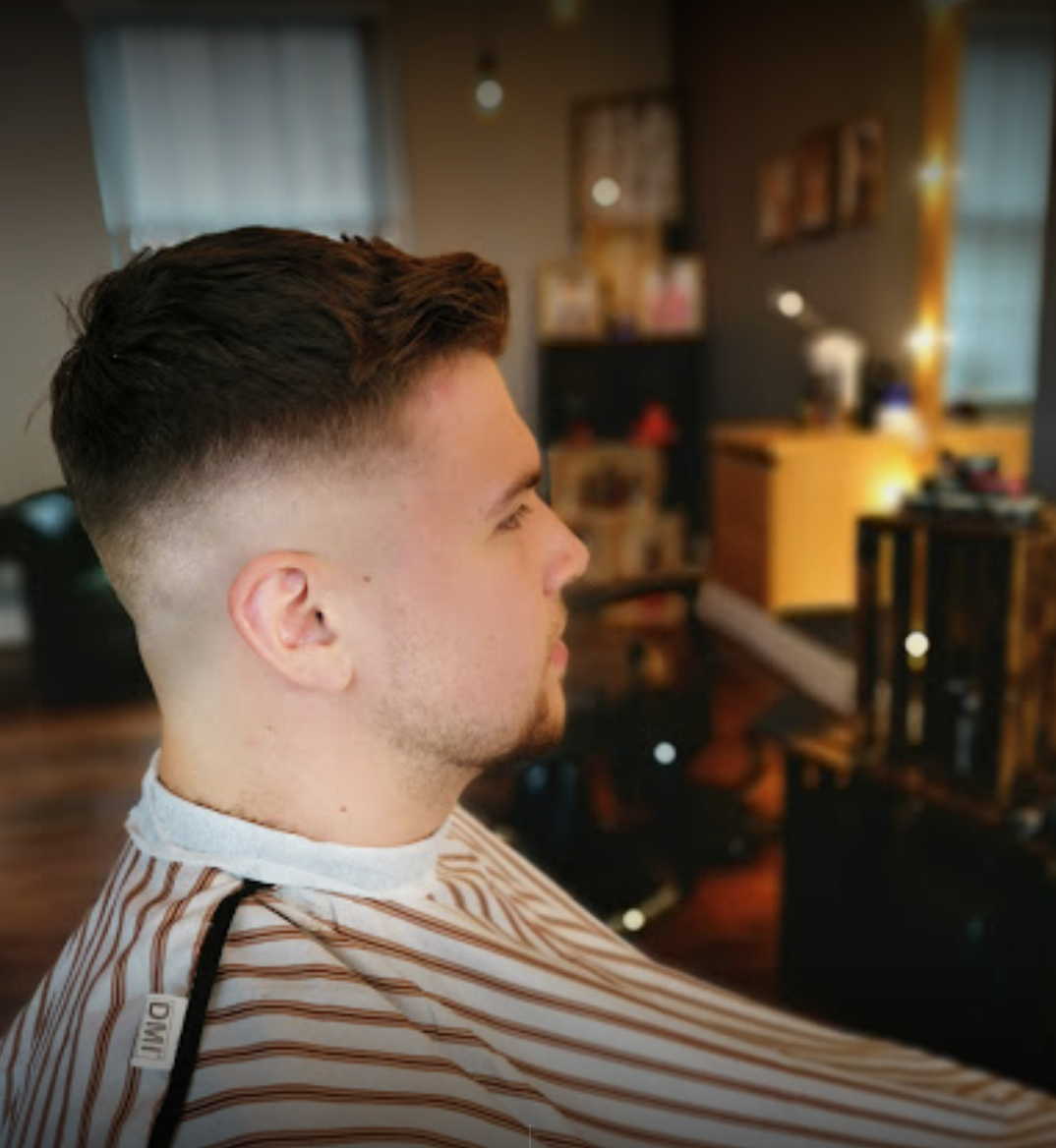 A man is getting his hair cut at a barber shop