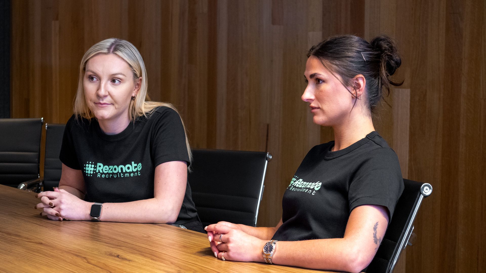 Group of people high-fiving in a modern office, celebrating a success.