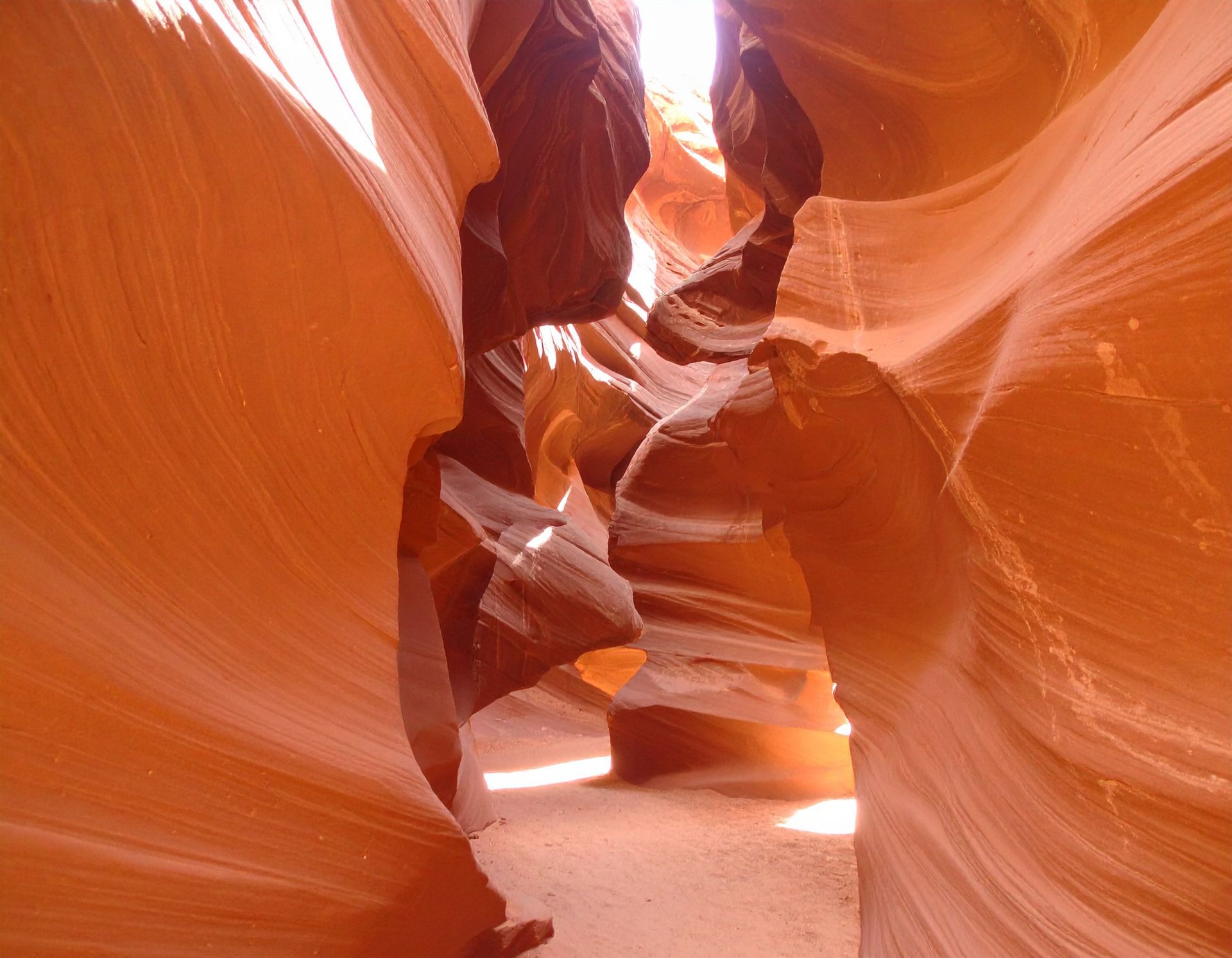 Red sandstone slot canyon with narrow passage and sunlight streaming through