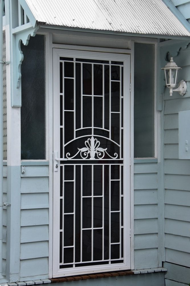 A White Door With A Black Screen On A Blue House — Browny's Glass & Aluminium in Gloucester, NSW