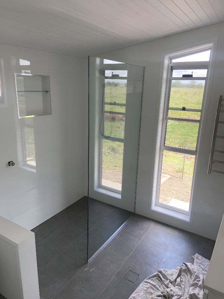A Bathroom With A Walk In Shower And Two Windows — Browny's Glass & Aluminium in Wingham, NSW